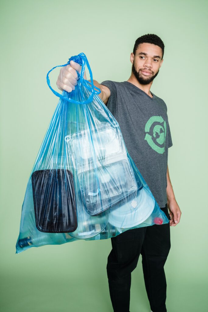 humain tenant un sac plastique rempli de plastiques